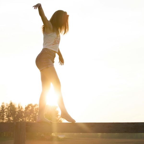 Person doing a flowing yoga movement outdoors during sunrise.